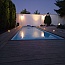 Osvetlený biely obdĺžnikový bazén pri stmievaní