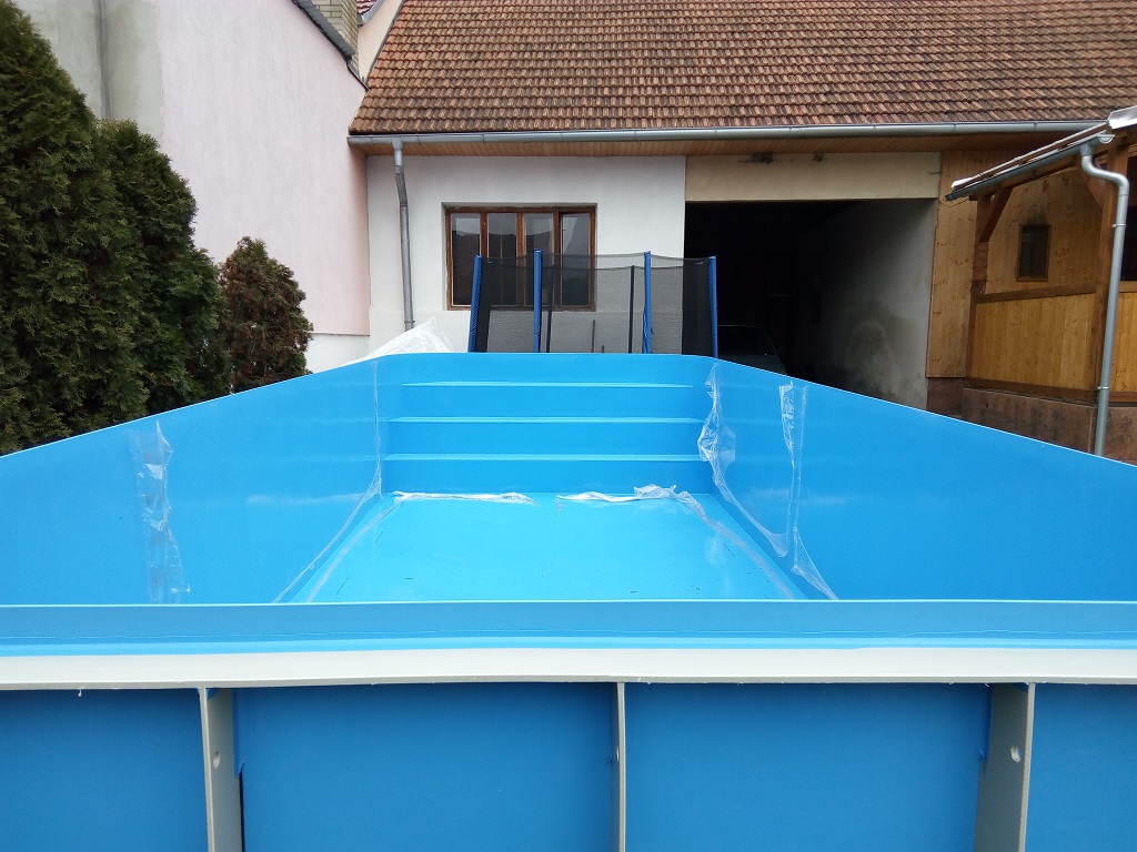Biely zaoblený plastový bazén do zeme s modrou lemovou rúrkou