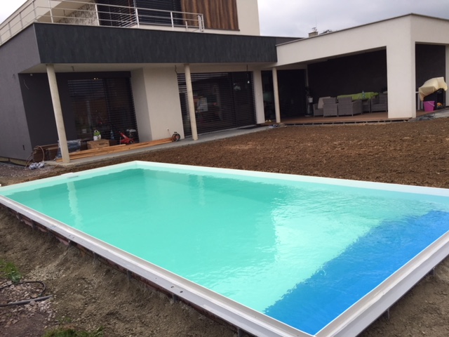 Biely zaoblený plastový bazén do zeme s modrou lemovou rúrkou